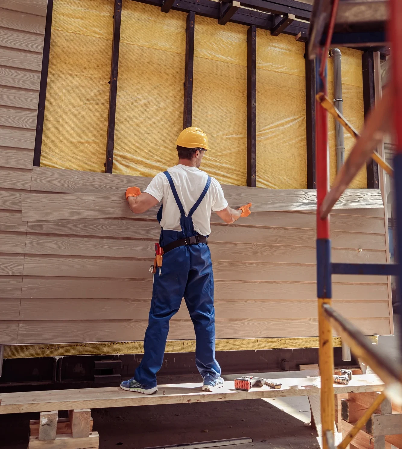 Male builder building house at construction site